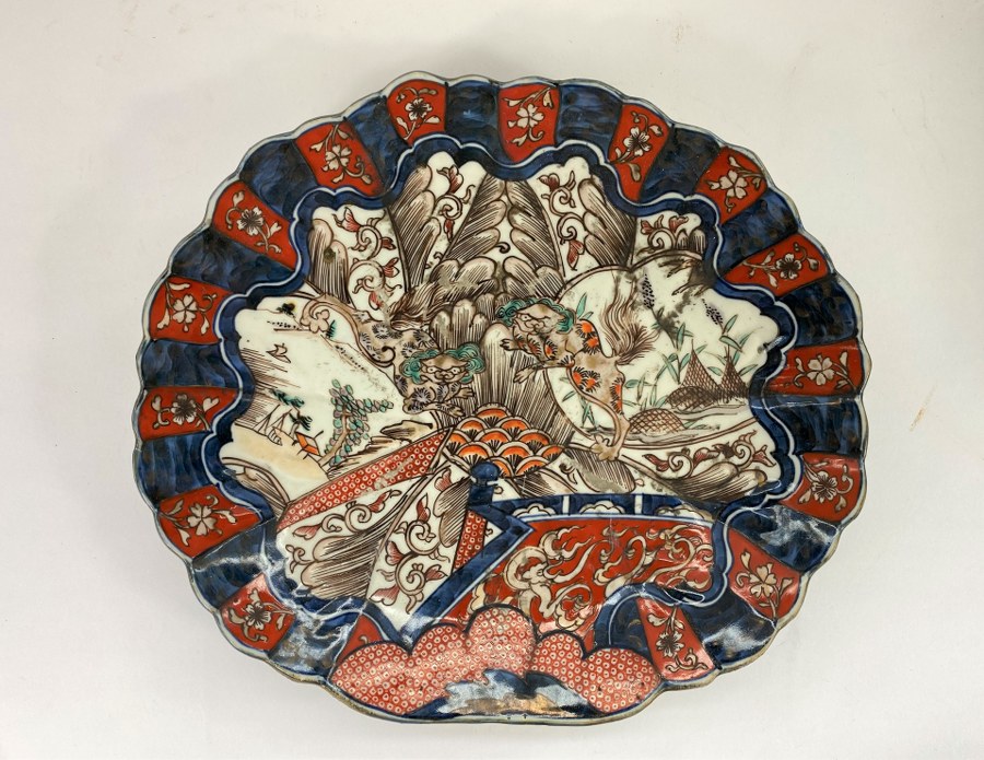 Plat en porcelaine Imari à décor de paysage asiatique. Usures.