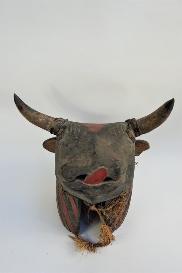 Masque-heaume BIDJOGO zoomorphe représentant le taureau sauvage de la mythologie du peuple Bidjogo. Bois sculpté polychrome, cornes et cuir, fibres végétales, verre. XXe siècle. Guinée-Bissau.